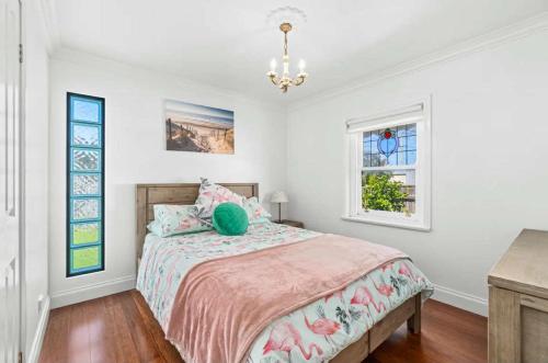 a bedroom with a bed and a chandelier at Mini Beach Cottage - Seaspray Escape in Seaspray