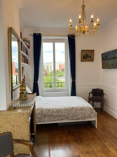 a bedroom with a bed and a window at Appartement - Parking Gratuit - Métro in Villeurbanne