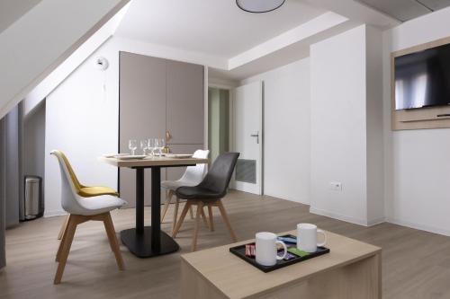 Un comedor y una sala de estar con mesa y sillas. en Appart Hotel Odalys City Strasbourg Green Marsh, en Estrasburgo