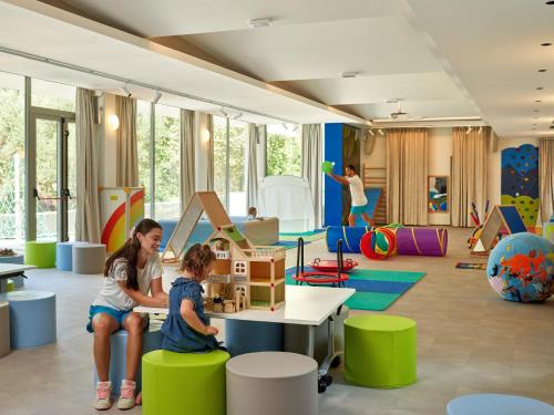 a childrens play room with children playing with a toy house at Maistra Select Mlini Villas and Apartments in Mlini