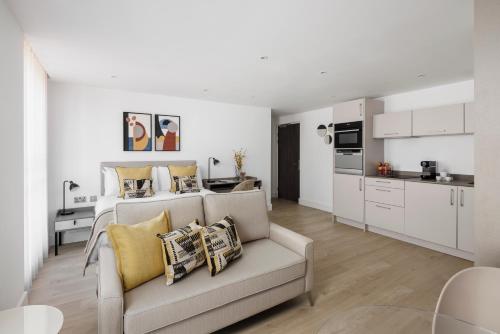 a living room with a couch and a kitchen at The Jubilee by Supercity Aparthotels in Leeds