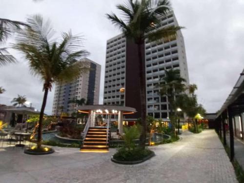 uma rua da cidade com palmeiras e um prédio em Salinas GAV Resort Premium Park Exclusive em Salinópolis
