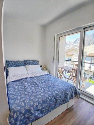 a bedroom with a bed and a balcony at La Casa Sorella in Prčanj