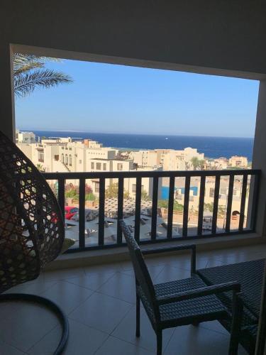 a balcony with a chair and a view of the ocean at Azzura Sahl Hasheesh in Hurghada