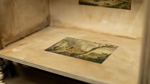 a table with a painting of a bird on it at Paradise Penthouse in Downham Market
