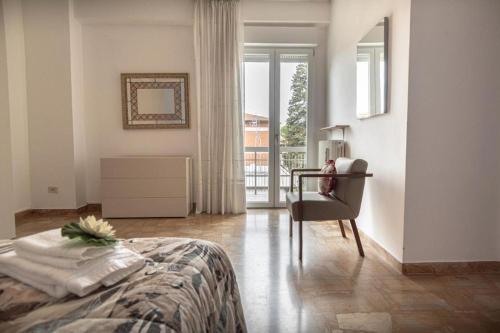 une chambre avec un lit, une chaise et une fenêtre dans l'établissement Appartamento Pennazzi, à Santa Maria degli Angeli