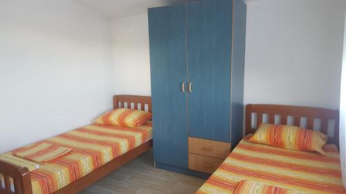 een slaapkamer met 2 bedden en een blauwe kast bij Apartments Diva in Dobra Voda