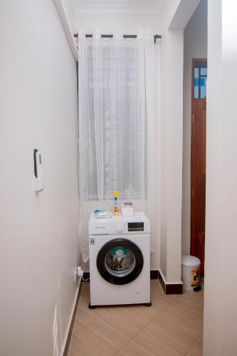 a washer and dryer in a room with a window at Reza stays apartment -Makumbusho behind Mwanga Tower in Dar es Salaam