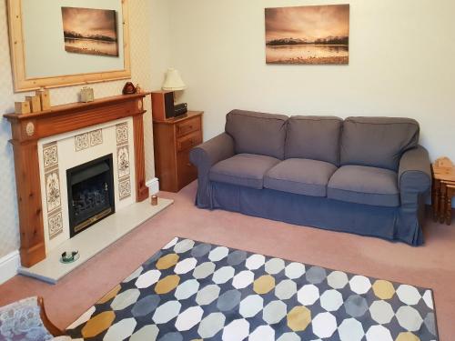 a living room with a couch and a fireplace at Robinson in Keswick