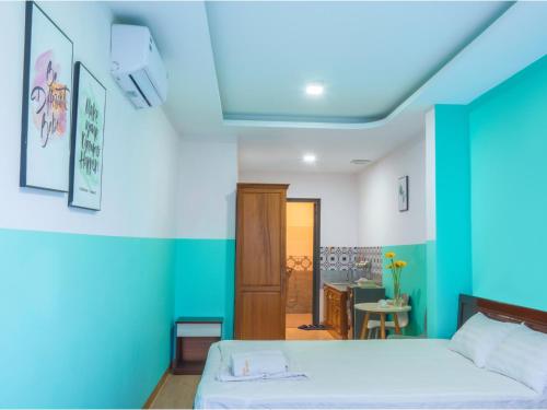 a bedroom with a bed and a blue wall at BOO Hostel , By the Beach in Da Nang