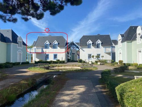a group of houses with a stream in front of them at Cap sur les Dunes, appartement à Belle Dune in Fort-Mahon-Plage
