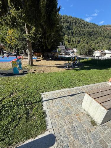 a park with a bench next to a tree at GIULY Apartment in Aprica