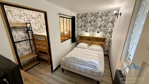 a small bedroom with a bed and a staircase at Le Bélouga 4 Le Mont Dore 6pers in Mont-Dore