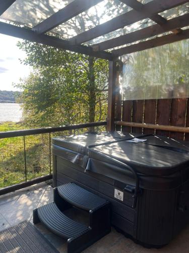 a hot tub on a deck with a pergola at Mountview Pod in Lochinver