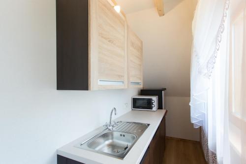a kitchen with a sink and a microwave at Szarotka in Bukowina Tatrzańska