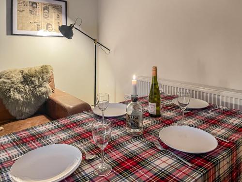 a table with plates and wine glasses on it at Fonseca Cottage in Aberfeldy