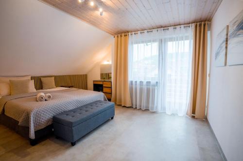 a bedroom with a bed and a large window at Ferienwohnung am Schwarzwald in Althengstett