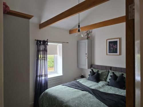 a bedroom with a bed and a window at Oak Cottage with private log fired hot tub in Maidstone