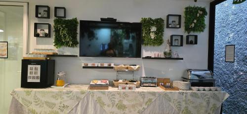 a table with a white table cloth and a tv on a wall at Apartamentos Turisticos Paraiso in Funchal
