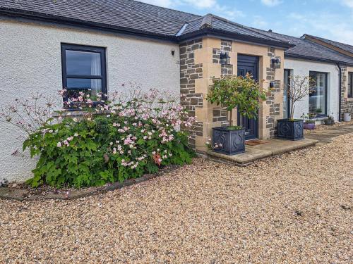 a house with some flowers in front of it at The Old Stables in Howwood