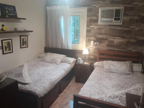 a bedroom with two beds and a window at Quiet Living in Cairo