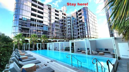a swimming pool in front of a building at Resort-style Exec 1 Bed with study in Port Melbourne in Melbourne
