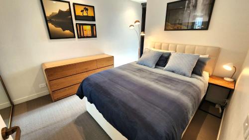a bedroom with a bed and a dresser in it at Resort-style Exec 1 Bed with study in Port Melbourne in Melbourne