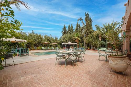 a patio with a table and chairs next to a pool at Dar Salah - Eddine Oasis Pool & SPA in Oulad Mazoug