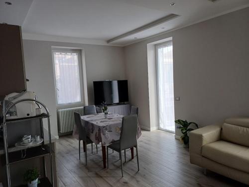 a living room with a table with chairs and a couch at Garden House in Sanremo