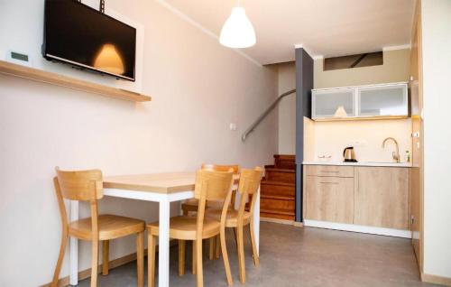 a kitchen and dining room with a table and chairs at 1 Bedroom Cozy Apartment In Okoniny Nadjeziorne in Okoniny Nadjezierne