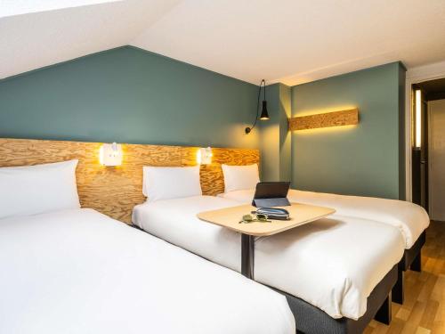 a room with two beds and a laptop on a table at greet Brussels Airport Zaventem in Zaventem
