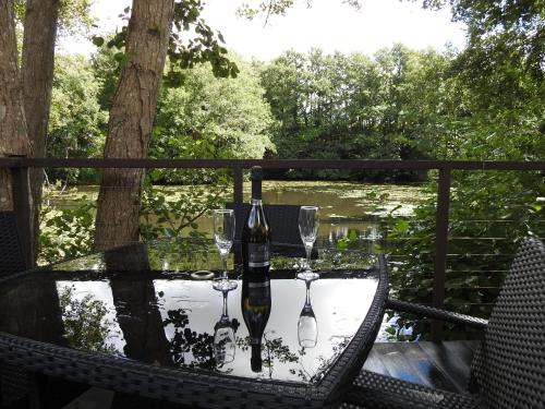 a table with two wine glasses and a bottle at Warren Wood Country Park in Polegate