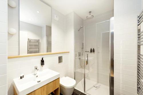 a bathroom with a sink and a shower and a toilet at Wilde Aparthotels Berlin, Checkpoint Charlie in Berlin