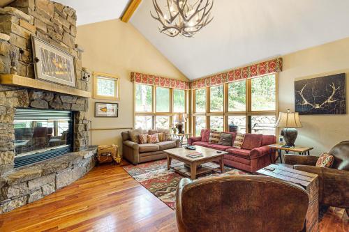 a living room with a fireplace and a stone wall at Moose Creek 26 in Teton Village