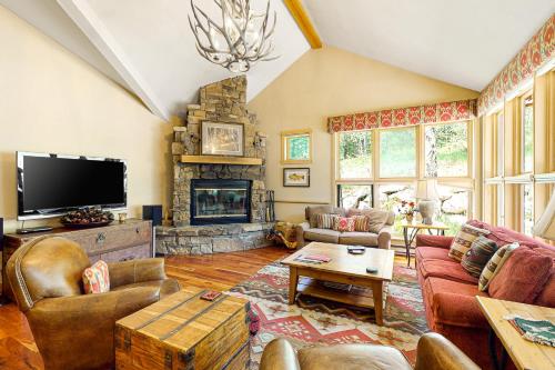 a living room with a fireplace and a tv at Moose Creek 26 in Teton Village