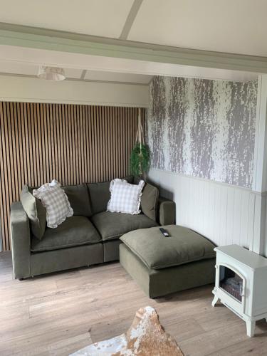 a living room with a couch and a table at The Shepherds Chalet in Garstang