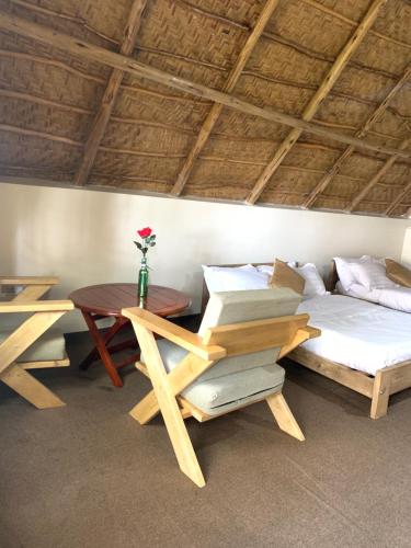 a room with a bed and a table and a bed and a table at Bugoma Palms Resort Sand Beach 