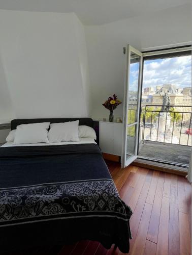 a bedroom with a bed and a large window at Eiffel Tower View Apartment in Paris