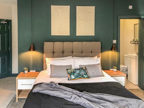 1 dormitorio con 1 cama grande y paredes verdes en Snowdon House, en Porthmadog