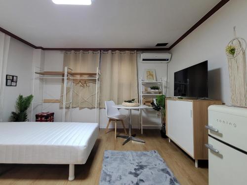 a bedroom with a bed and a table and a tv at The stay Paju in P'aju