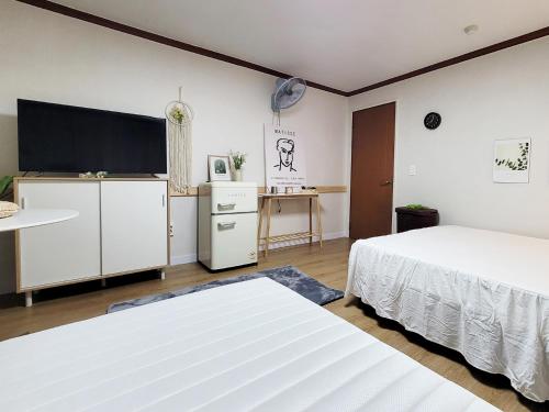 a bedroom with two beds and a flat screen tv at The stay Paju in P'aju