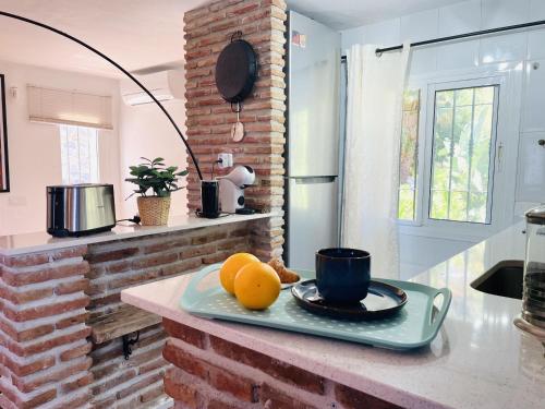 a kitchen counter with a plate of oranges and a cup at Villa Jina con piscina by At Home Costa del Sol in Torrox