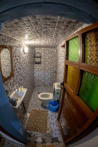 a bathroom with a toilet and a sink and a door at Riad Misk Fez in Fès