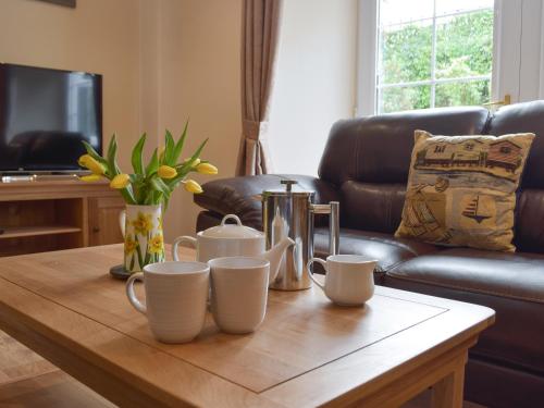 a coffee table in a living room with a leather couch at Victoria House - Uk13380 in Llanstephan