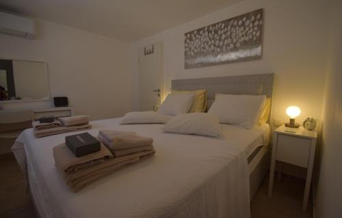 Un dormitorio con una cama blanca con toallas. en Ferienhaus Katarina by Villas Guide, en Šarići