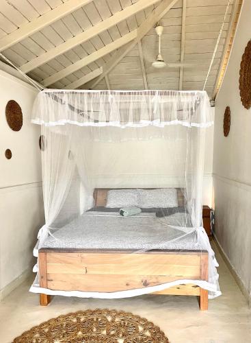 a bed with a canopy in a room at LAKE HOUSE - La maison VEDA in Habaraduwa