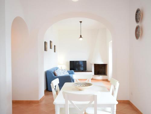 a living room with a table and chairs and a blue couch at Casa della Marina - beach, seaview, wifi in Conca dei Marini
