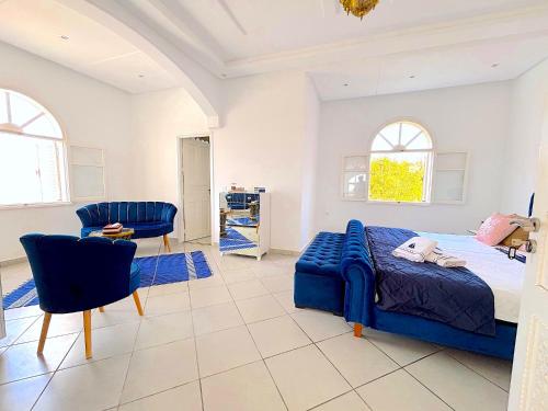 Un dormitorio con una cama azul y una silla. en Palais Kyra, en Ounara