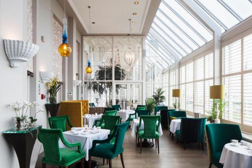 a dining room with tables and chairs and a glass ceiling at The Grand Brighton in Brighton & Hove