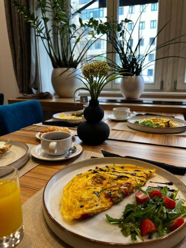 a table topped with plates of food and a pizza at Urban Boutique Hotel Center in Ljubljana
